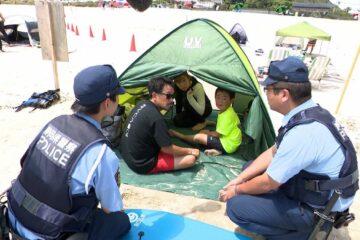 お盆前のビーチで白い砂浜を歩く『制服姿の警察官たち』水難事故防止へ…キーワードは「見せる …