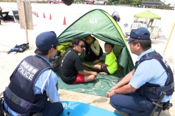 お盆前のビーチで白い砂浜を歩く『制服姿の警察官たち』水難事故防止へ…キーワードは「見せる …